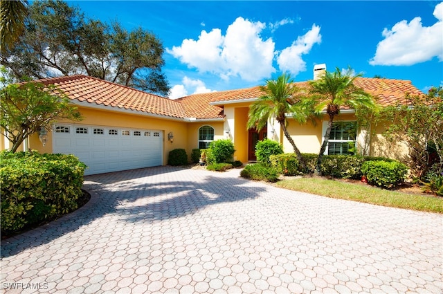 mediterranean / spanish-style house with a garage