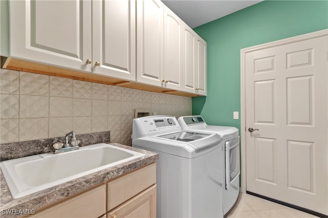 laundry area with cabinets, independent washer and dryer, light tile patterned floors, and sink