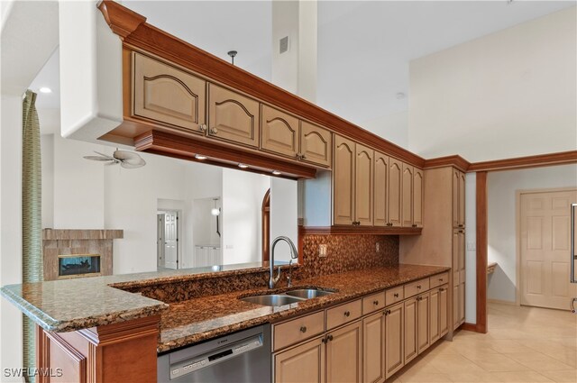 kitchen featuring dishwasher, a towering ceiling, dark stone countertops, and sink