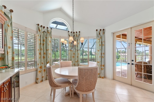 dining room featuring french doors, light tile patterned floors, a chandelier, and lofted ceiling