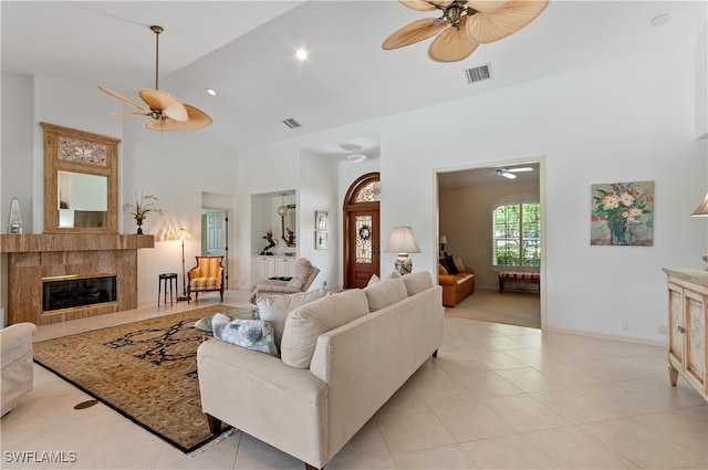 tiled living room featuring ceiling fan, a fireplace, and high vaulted ceiling