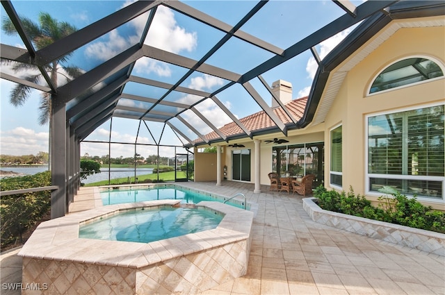 view of pool with glass enclosure, ceiling fan, an in ground hot tub, and a patio