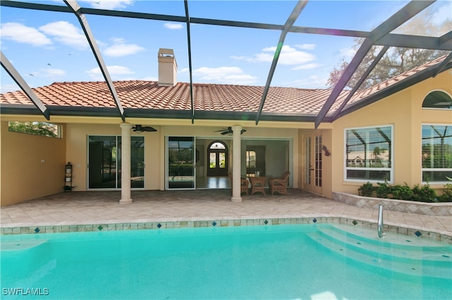 view of swimming pool featuring ceiling fan, a lanai, and a patio