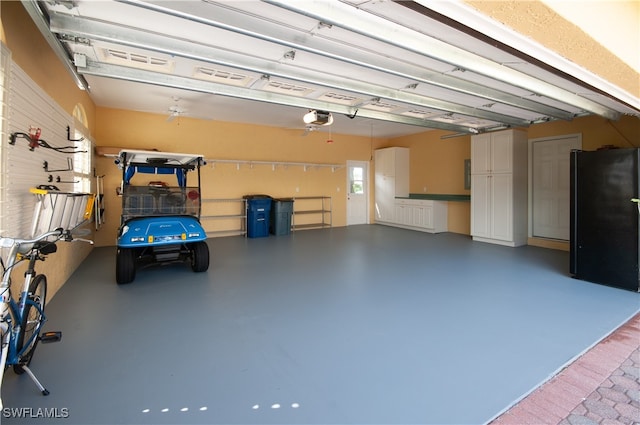 garage with black fridge and a garage door opener