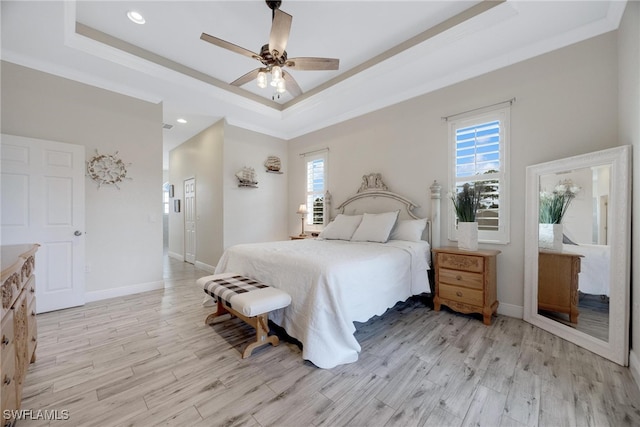 bedroom with crown molding, ceiling fan, a raised ceiling, and light wood-type flooring