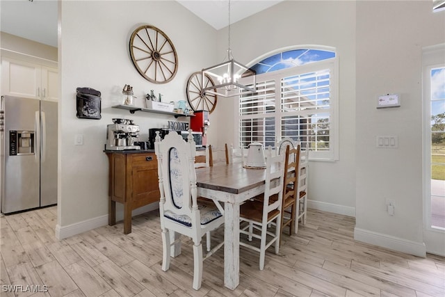 dining room with light hardwood / wood-style floors and a notable chandelier