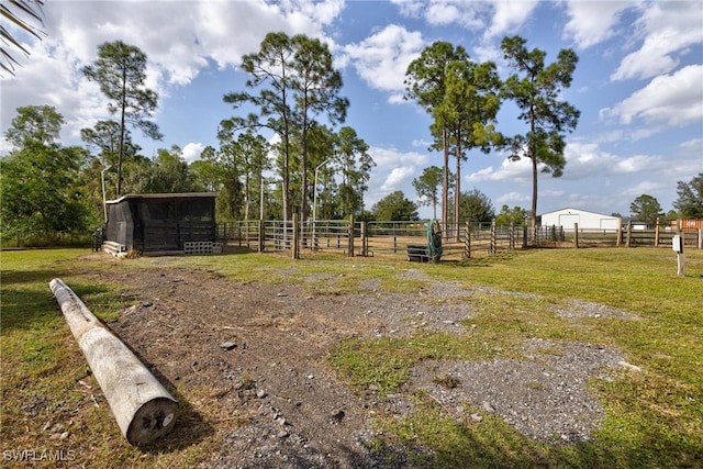 view of yard with a rural view and an outbuilding