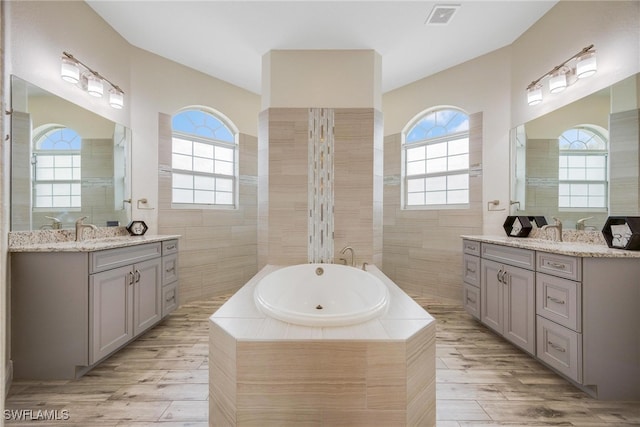 bathroom with a wealth of natural light, vanity, and hardwood / wood-style flooring