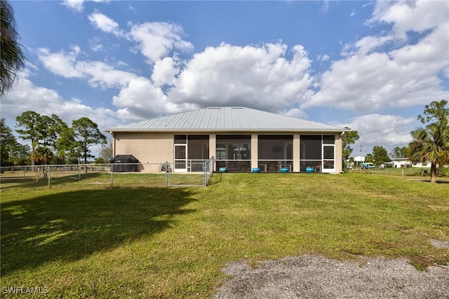 back of house featuring a yard and a sunroom