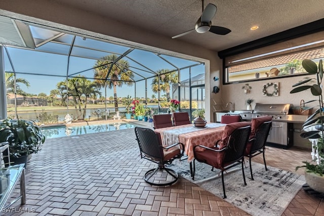 view of patio / terrace featuring ceiling fan, grilling area, and glass enclosure