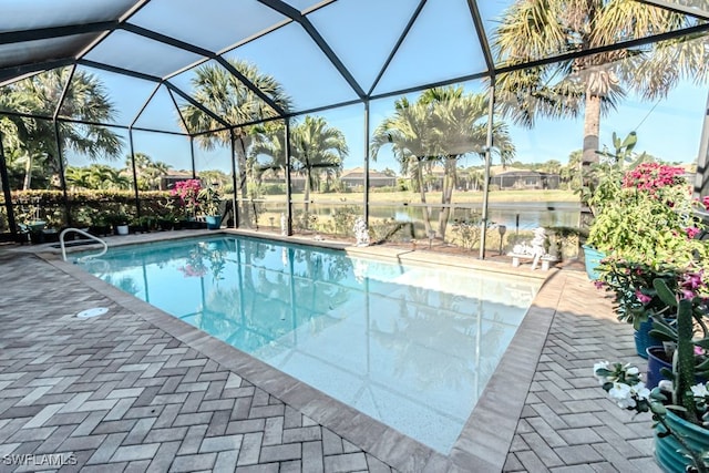 view of swimming pool with a patio, a water view, and glass enclosure