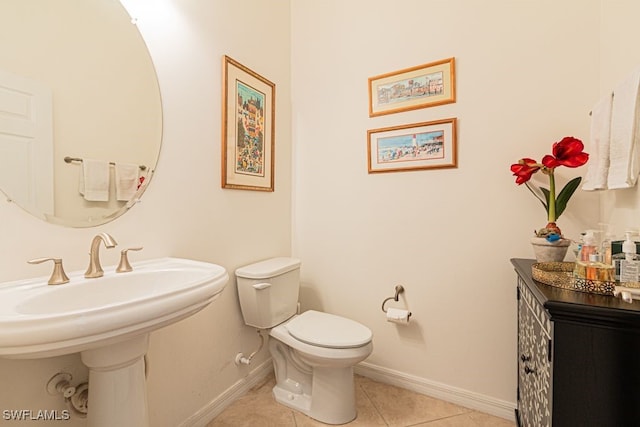 bathroom featuring toilet, tile patterned floors, and sink