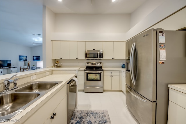 kitchen featuring stainless steel appliances, sink, and light tile patterned floors