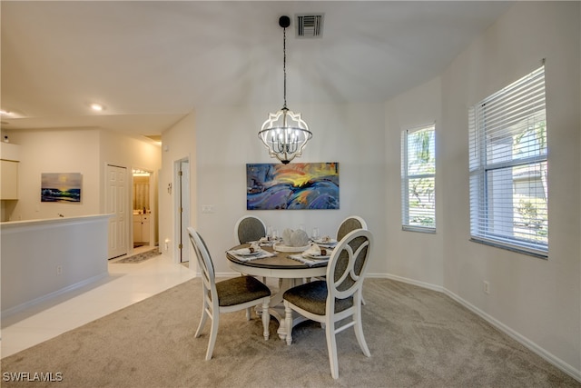 carpeted dining area featuring a chandelier