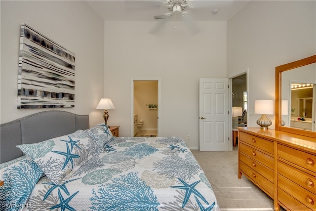 bedroom featuring connected bathroom, light carpet, high vaulted ceiling, and ceiling fan