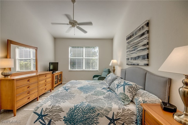 carpeted bedroom featuring multiple windows and ceiling fan