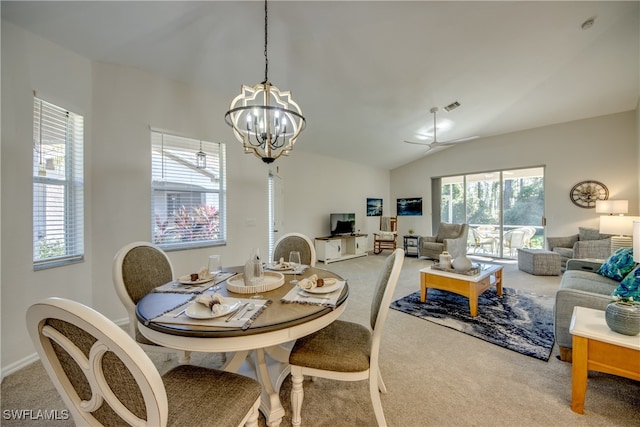 carpeted dining area featuring lofted ceiling, plenty of natural light, and ceiling fan with notable chandelier