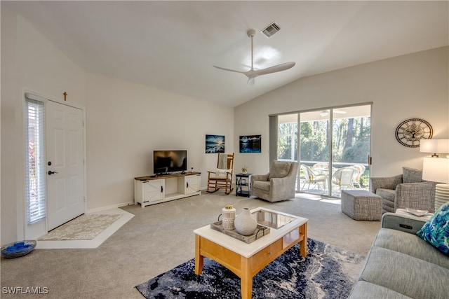 carpeted living room with ceiling fan and vaulted ceiling