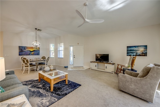 living room with carpet and ceiling fan with notable chandelier