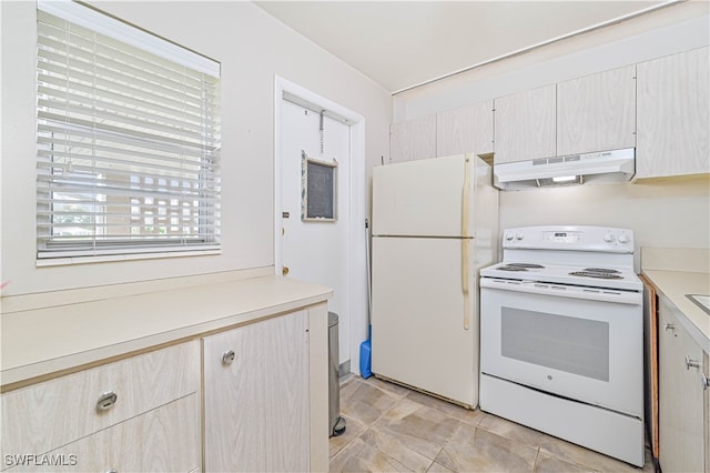 kitchen featuring light brown cabinetry and white appliances