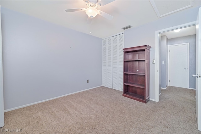 unfurnished bedroom featuring ceiling fan, a closet, and light colored carpet