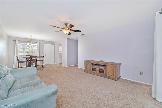 carpeted living room with ceiling fan with notable chandelier