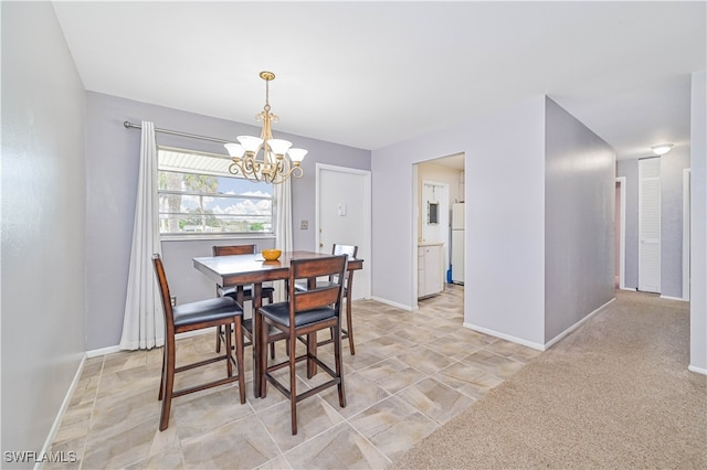 dining area featuring light carpet and a chandelier