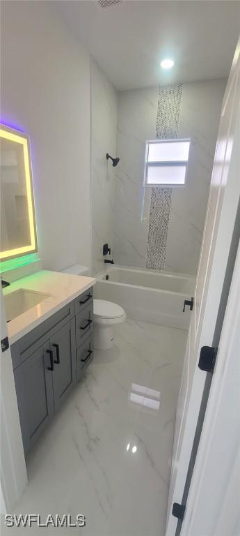 full bathroom with vanity, tiled shower / bath combo, and toilet