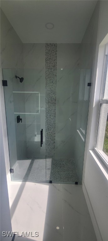 bathroom with a shower with door