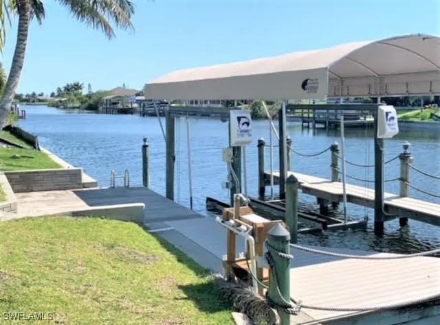 view of dock featuring a water view and a lawn