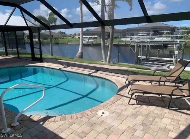 view of swimming pool featuring a water view, a patio, a lanai, and a boat dock