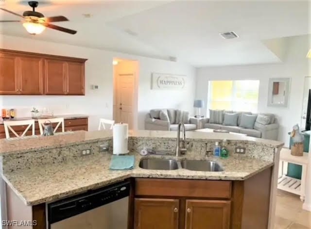 kitchen featuring sink, dishwasher, light stone counters, and ceiling fan