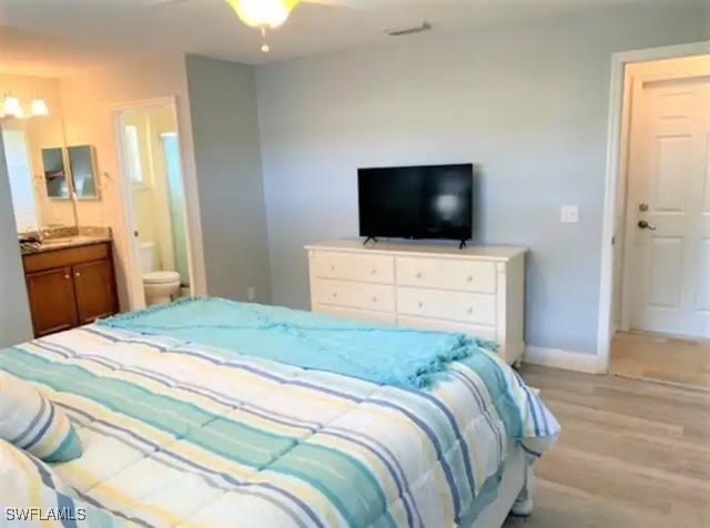 bedroom featuring ensuite bath and light hardwood / wood-style floors