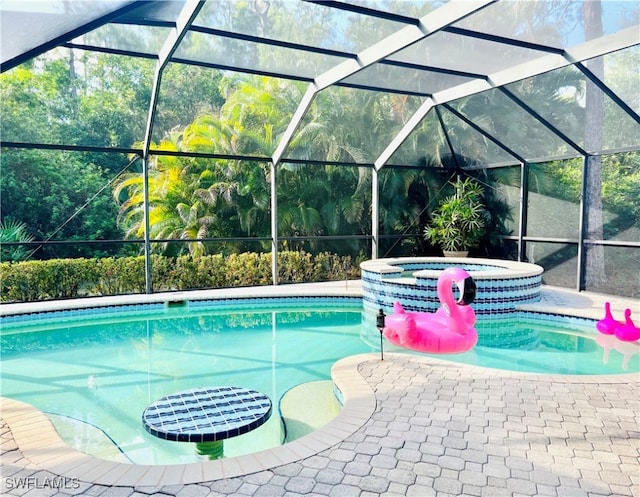 view of pool with an in ground hot tub, a patio area, and a lanai