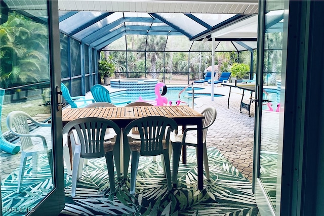 view of patio / terrace featuring a swimming pool with hot tub and a lanai