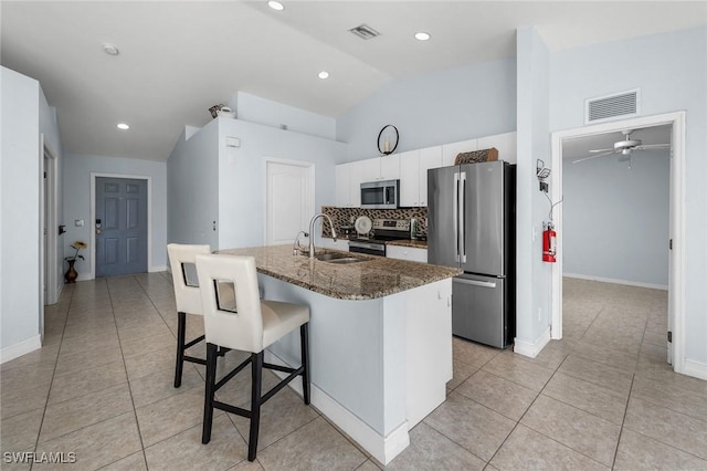 3615 4th St SW, Lehigh Acres, FL 33976 - kitchen with stainless steel appliances, a sink, light tile patterned flooring, vaulted ceiling, and a kitchen breakfast bar