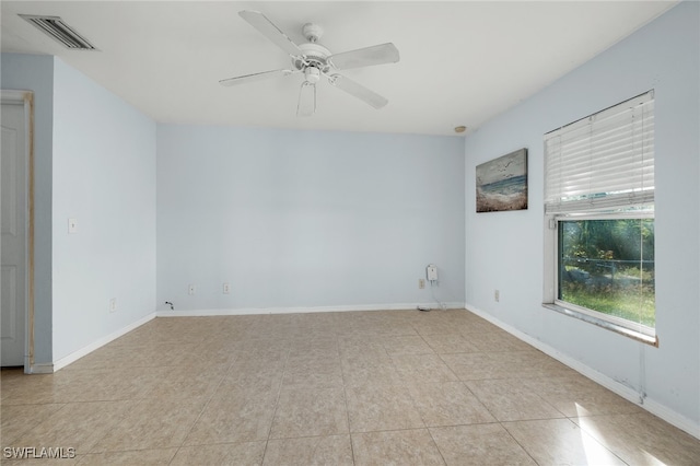 tiled empty room featuring ceiling fan