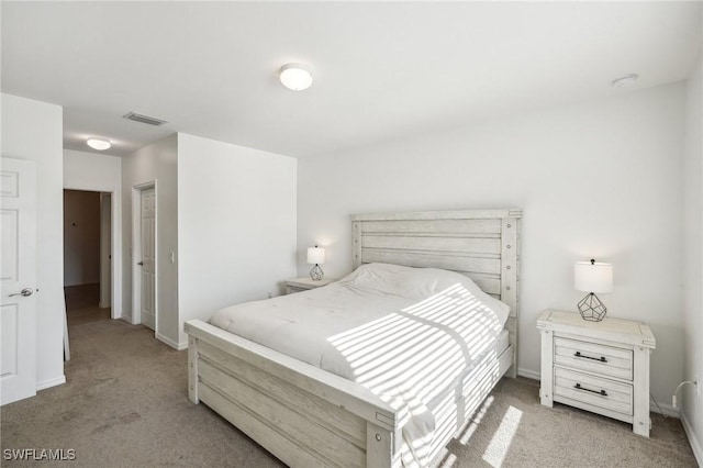 bedroom with light carpet, visible vents, and baseboards