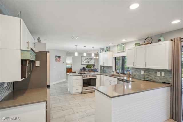 kitchen with hanging light fixtures, white cabinetry, kitchen peninsula, and gas stove