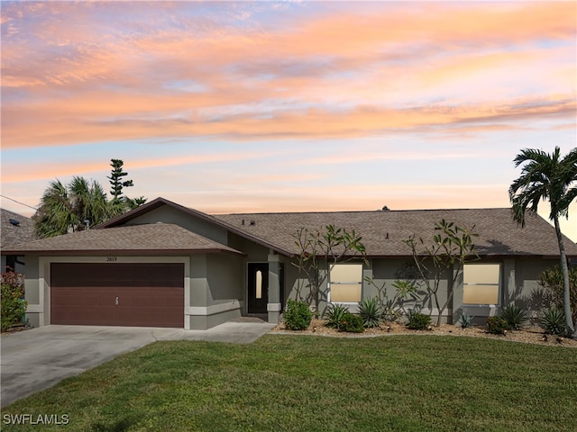 single story home with a lawn and a garage