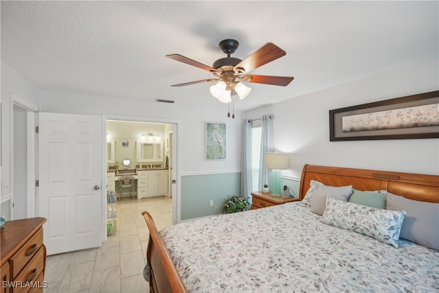 bedroom featuring ceiling fan, a textured ceiling, and ensuite bath