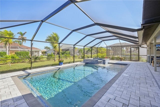 view of pool featuring a lawn, an in ground hot tub, a patio area, and glass enclosure