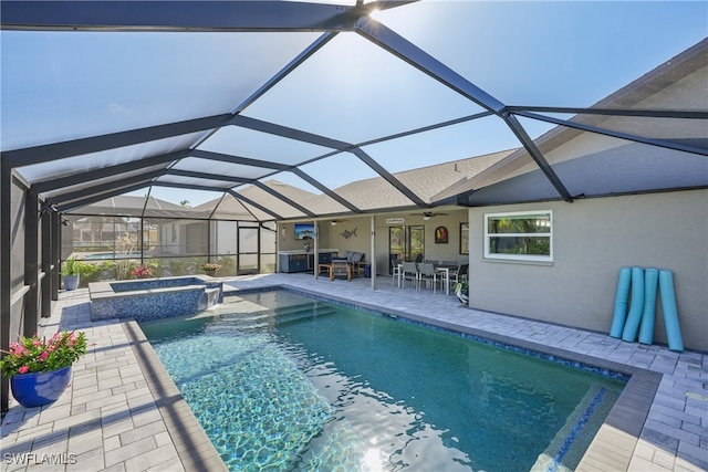 view of swimming pool featuring a patio area, an in ground hot tub, and glass enclosure