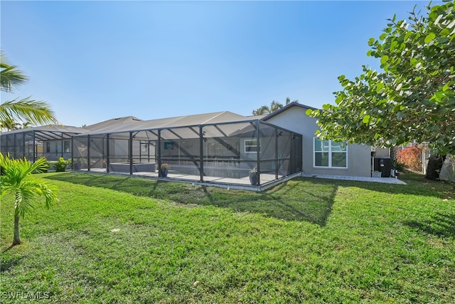 back of house with glass enclosure and a lawn