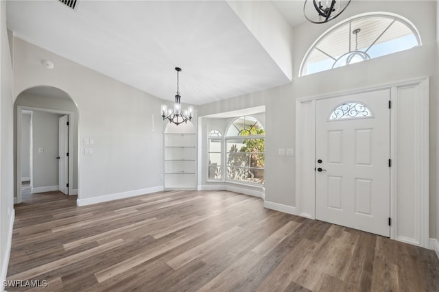 foyer with wood-type flooring and an inviting chandelier