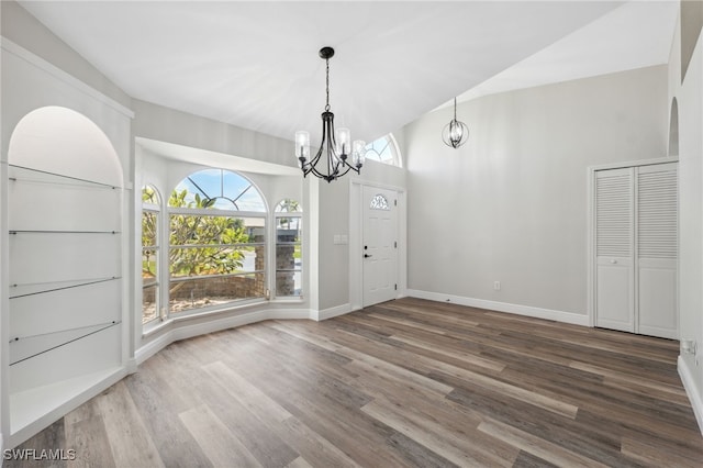 unfurnished dining area featuring a chandelier and wood-type flooring