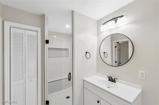 bathroom featuring a shower with door and vanity