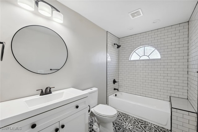 full bathroom with tiled shower / bath combo, toilet, and vanity