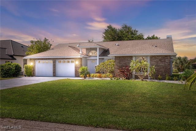 ranch-style house featuring a yard and a garage