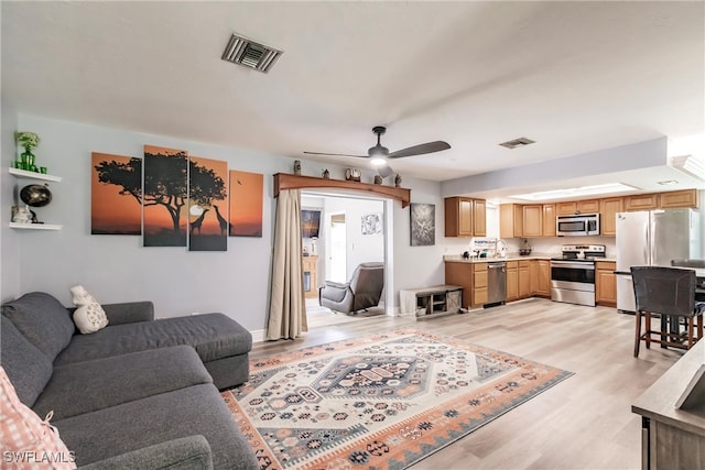 living room with light wood-type flooring and ceiling fan